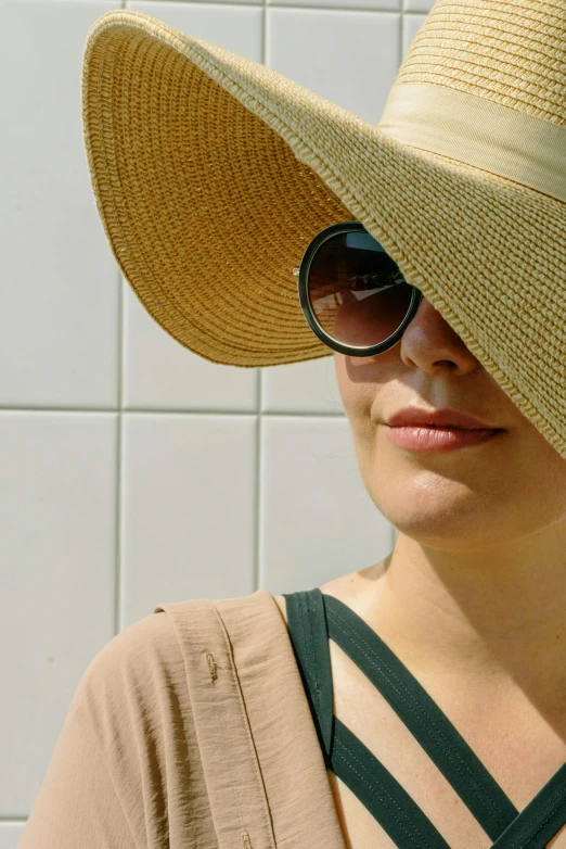 a woman with large sunglasses on her head and a hat in her lap