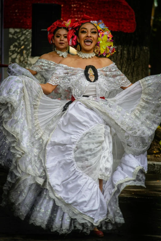 two woman in white dresses dancing together