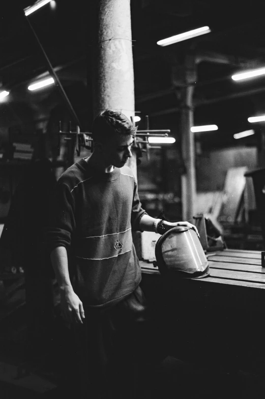 a man in a factory holding a pan over an open lid