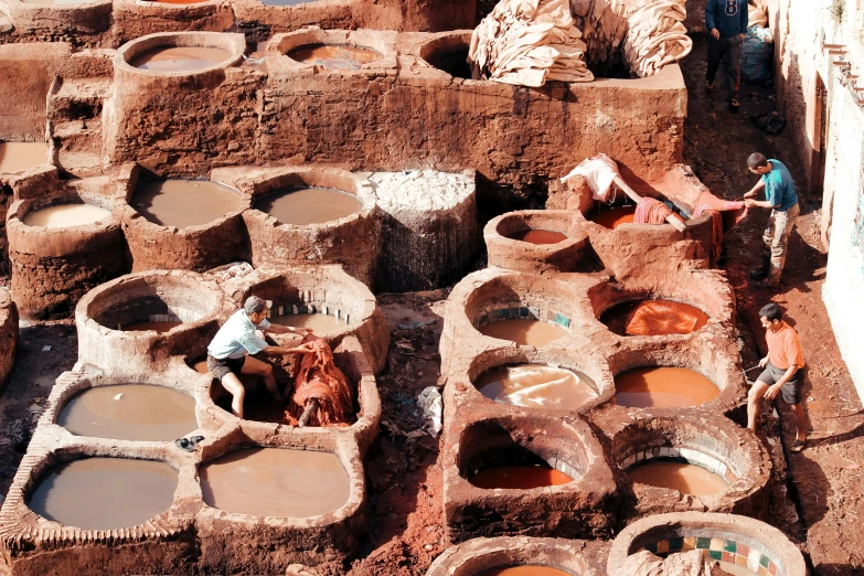 many different clay structures with people walking around