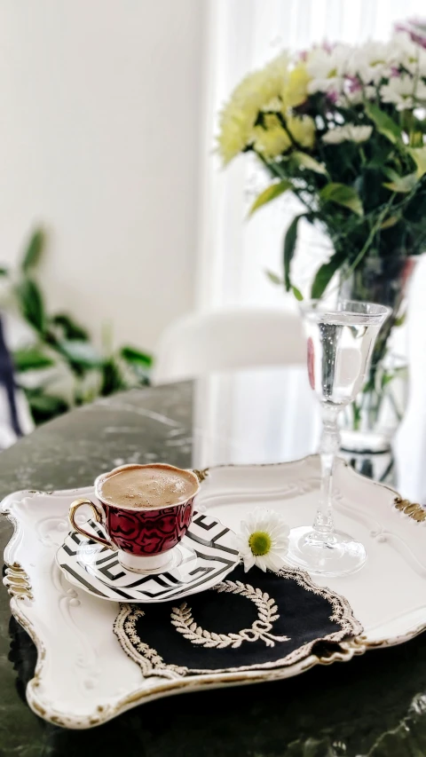 a small glass vase with flowers next to a table