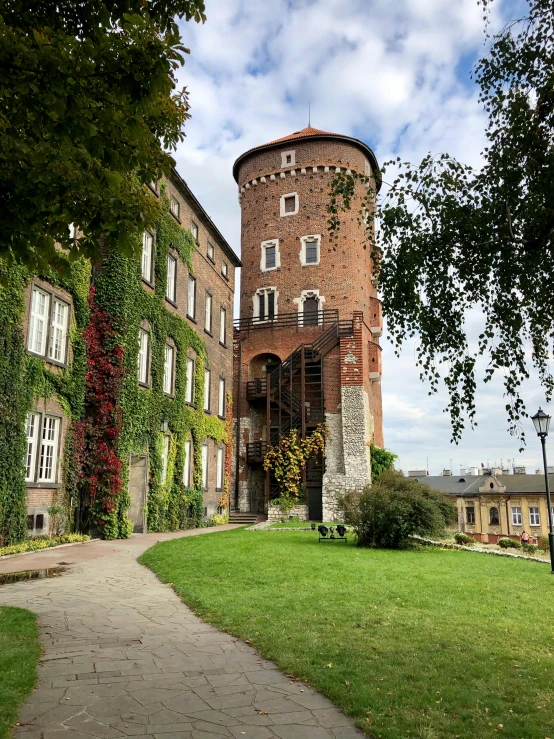 the house is tall and brick, and has green grass growing around it