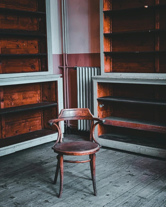 an antique chair in front of some old book cases