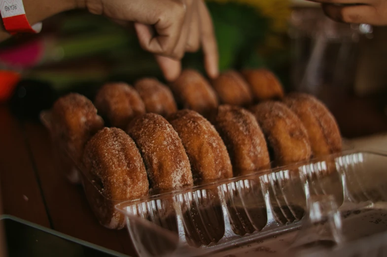 a person places donuts on plates in a row