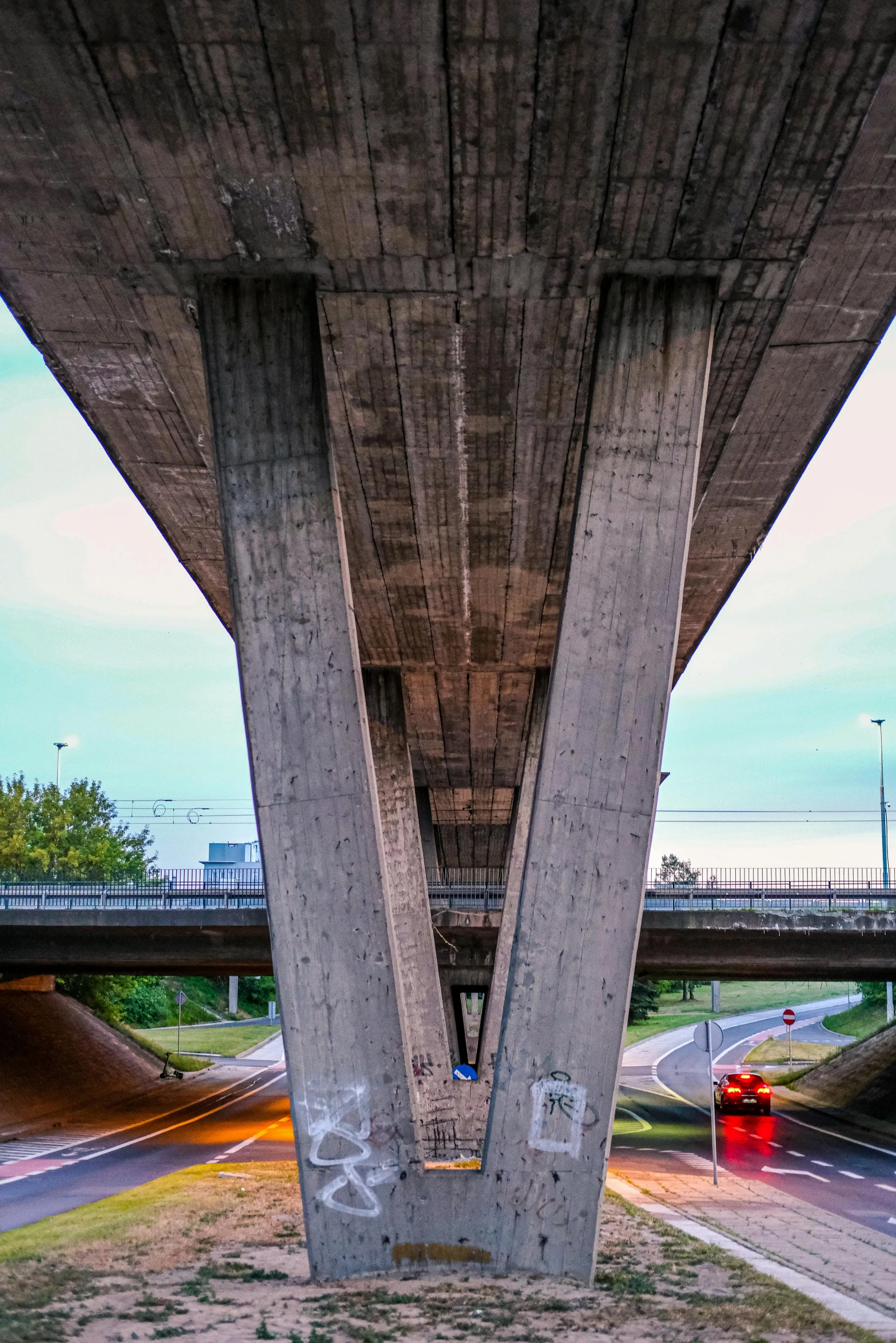 underneath the bridge is an overpass that shows two street and cars