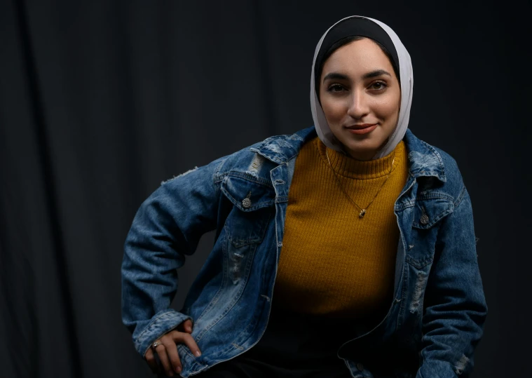 a young woman posing in front of black backdrop