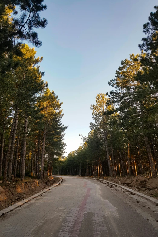 the road is empty and there is a few people walking down it