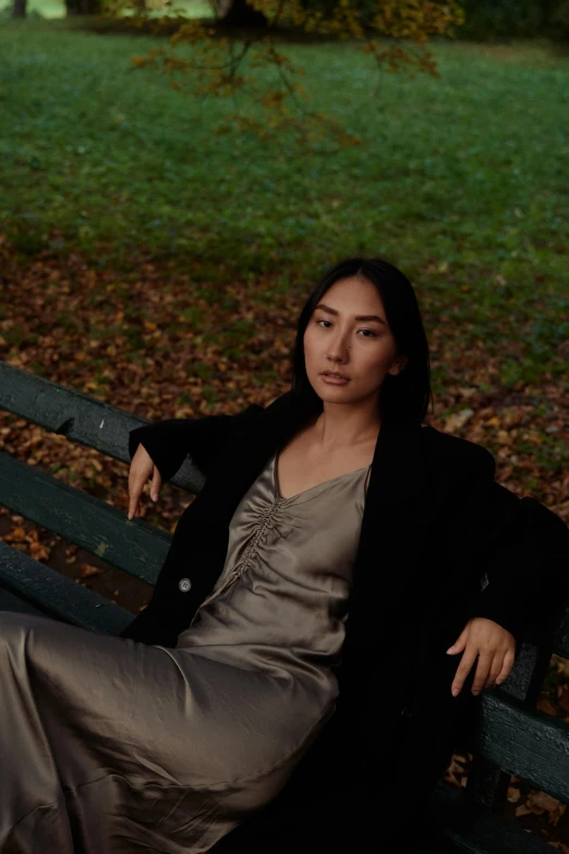 a young woman sitting on top of a wooden bench