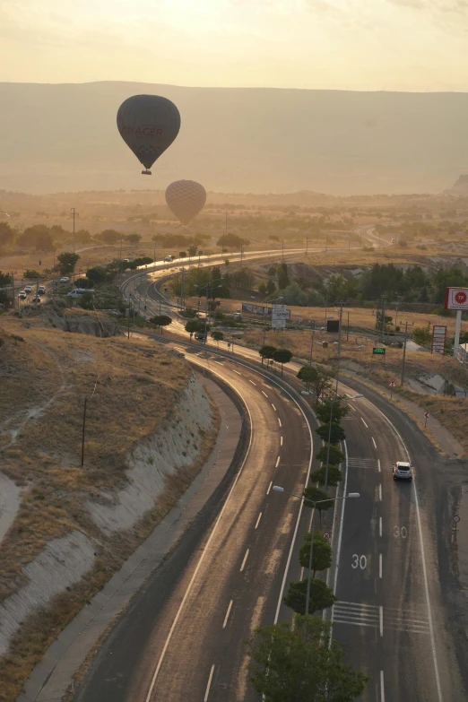 three balloons that are flying above a city