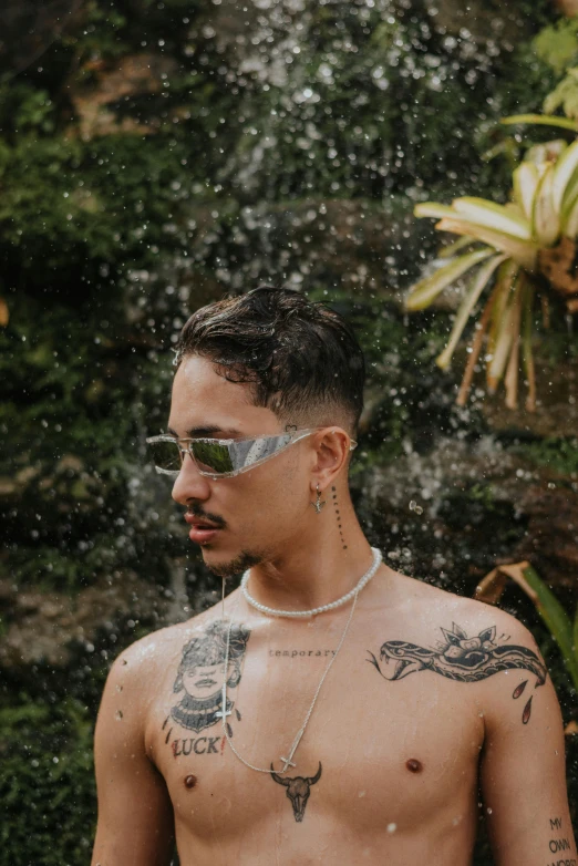 man in white bikini with tattoos standing under rain