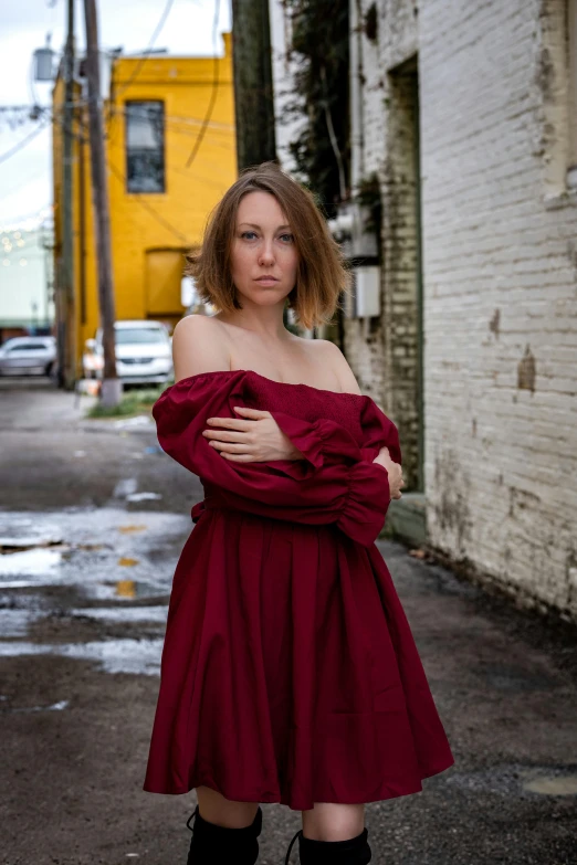 a woman is wearing boots and standing next to the street