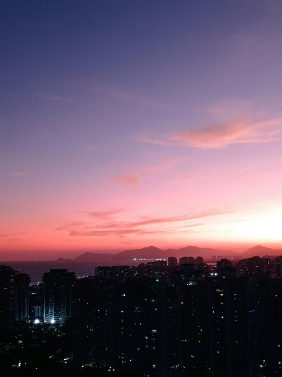 a purple and orange sunset over city buildings