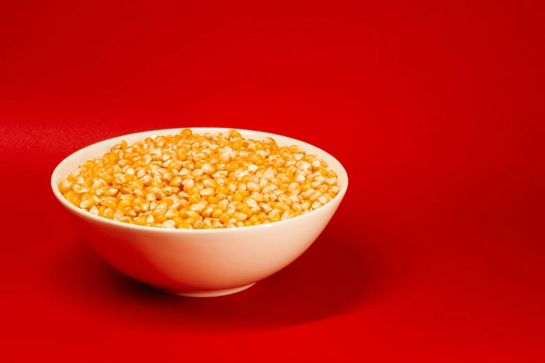 corn in a white bowl with red table top