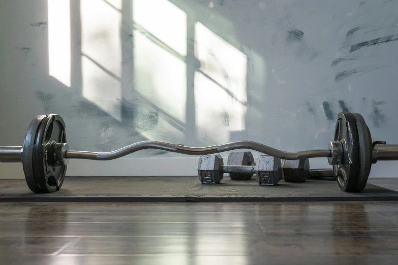 a metal barbell with two large steel wheels, on the floor