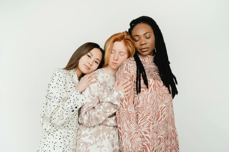 three women standing side by side in the same clothes