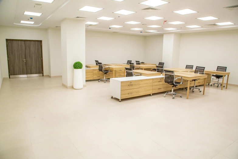 a large meeting room with lots of desks and chairs