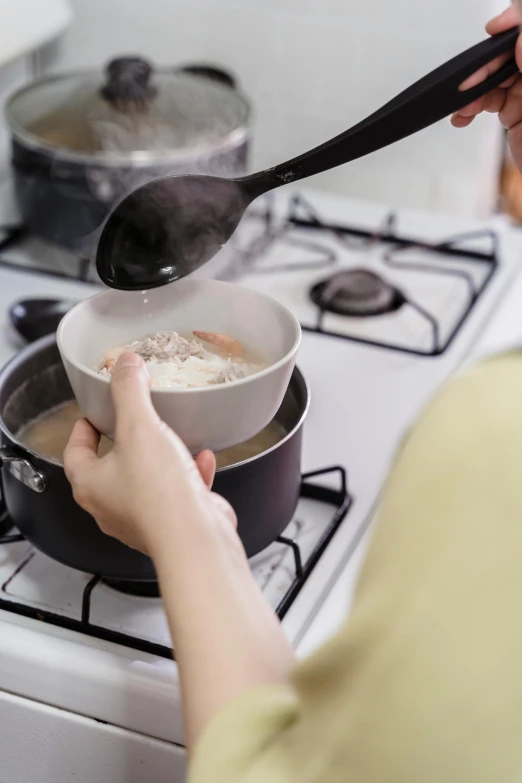 someone stirring soing in the bowl of the oven