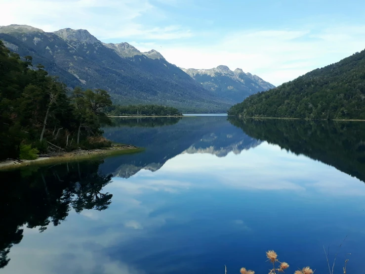 a still river and mountains in the distance