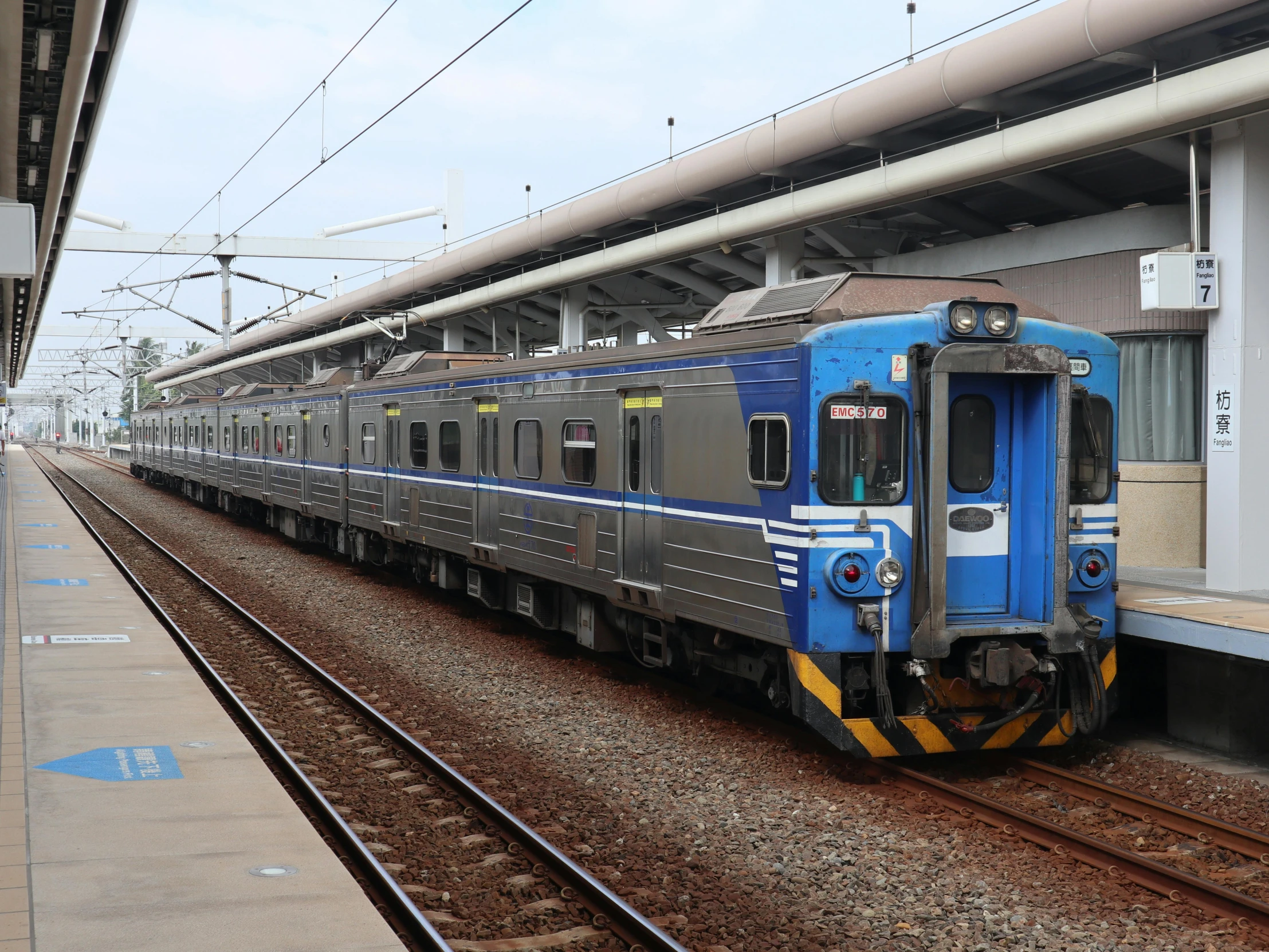 a blue train pulling into the station, waiting