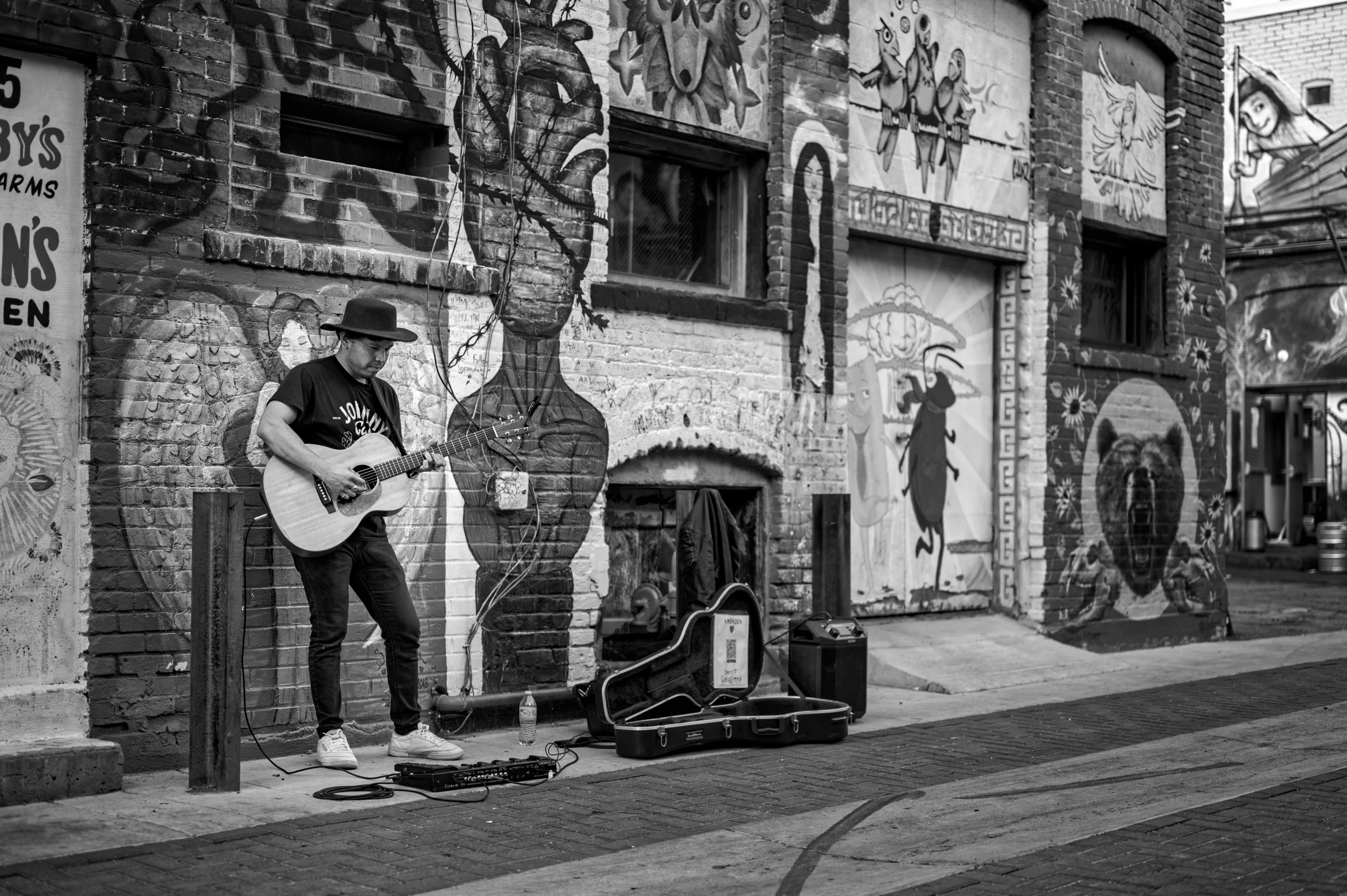 a man playing an acoustic guitar in front of a building