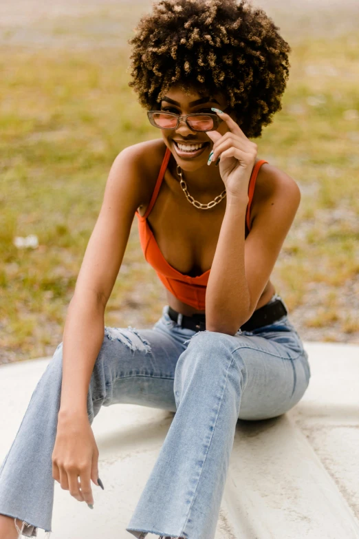 a woman in glasses sits on the edge of a bench and looks into her left eye