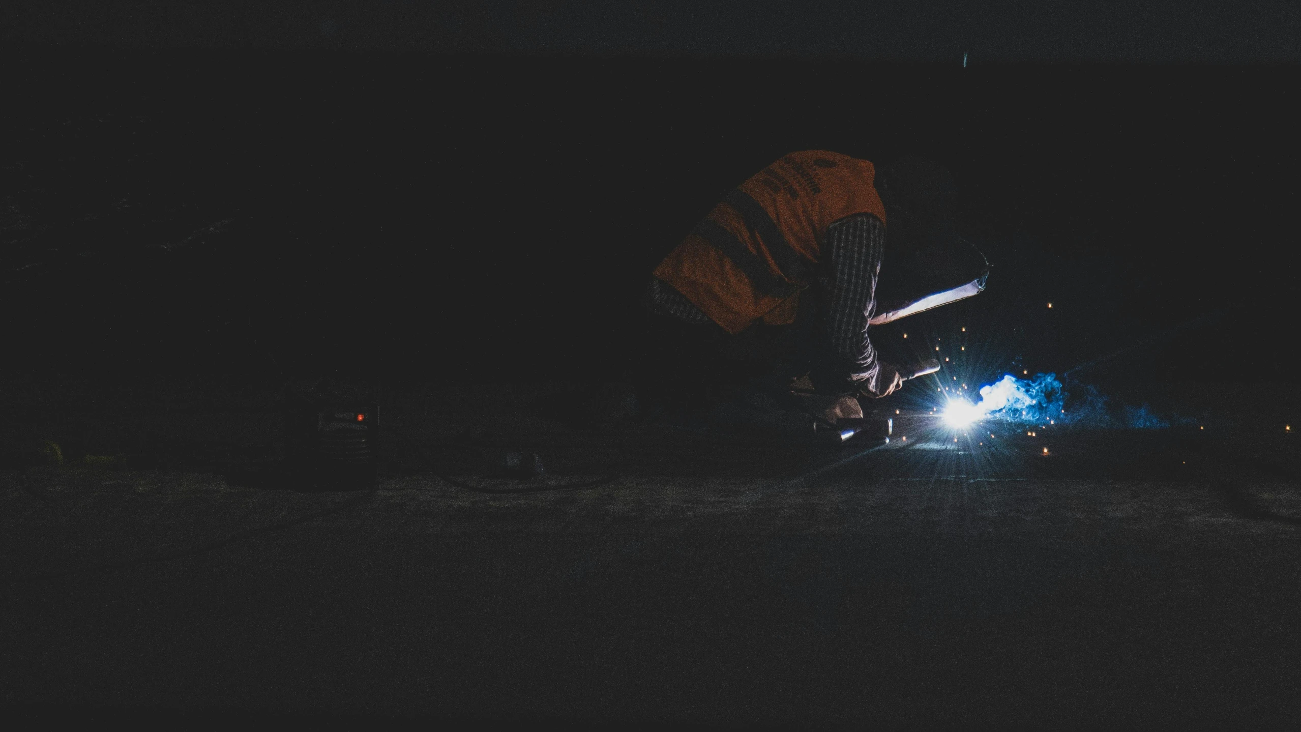 two people standing near a lit up umbrella at night