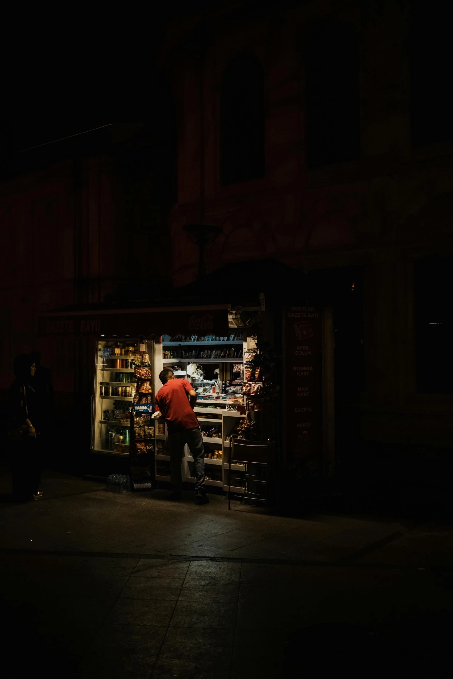 a woman is selling items in the dark