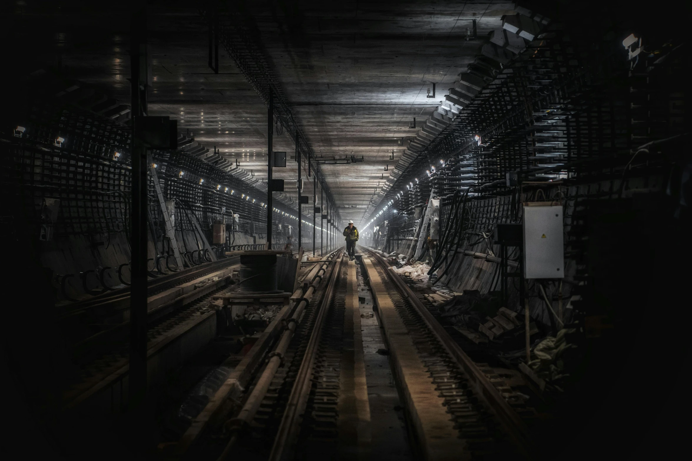 a train station with tracks and a person in the background