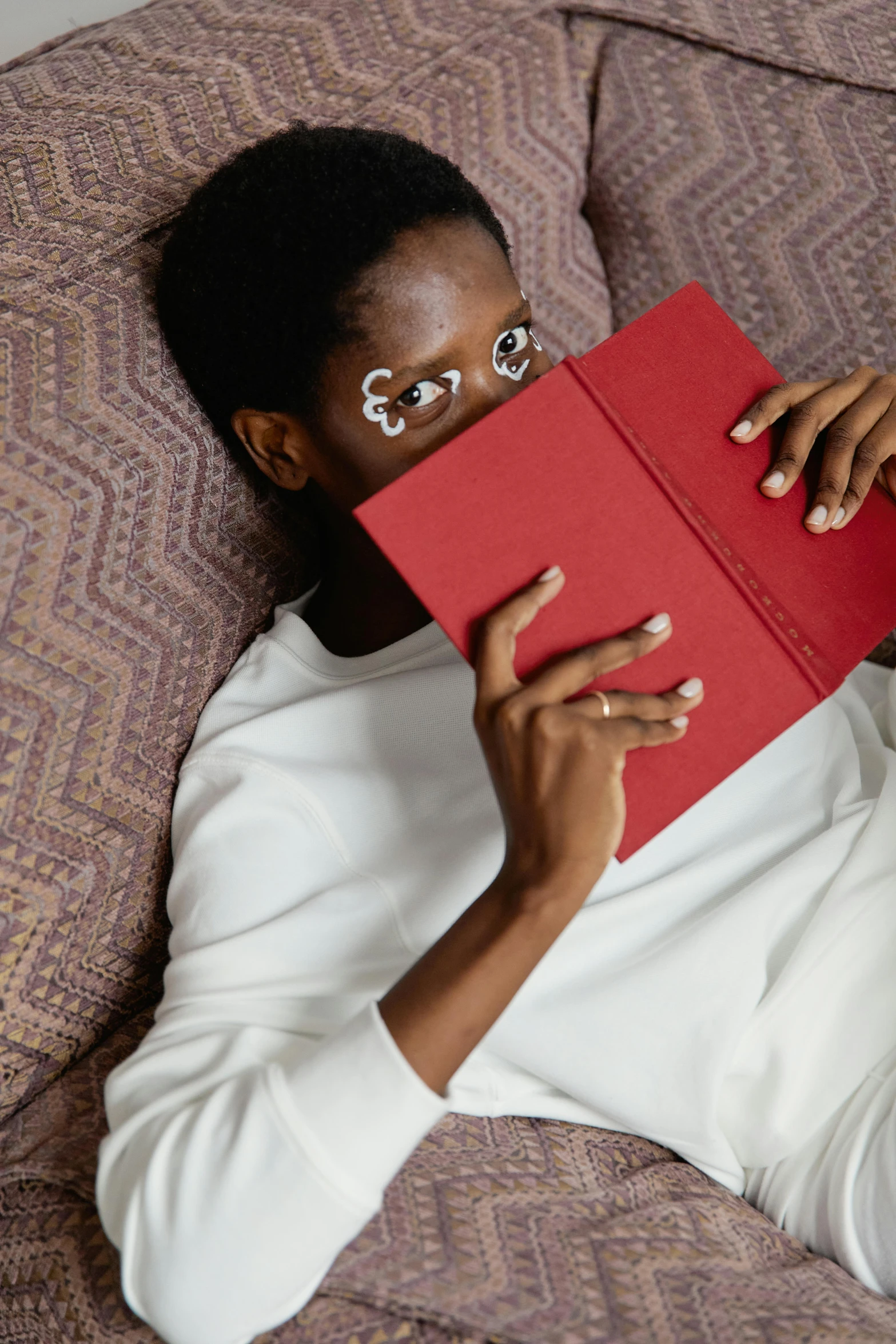 a woman reading a book with glasses and red folder