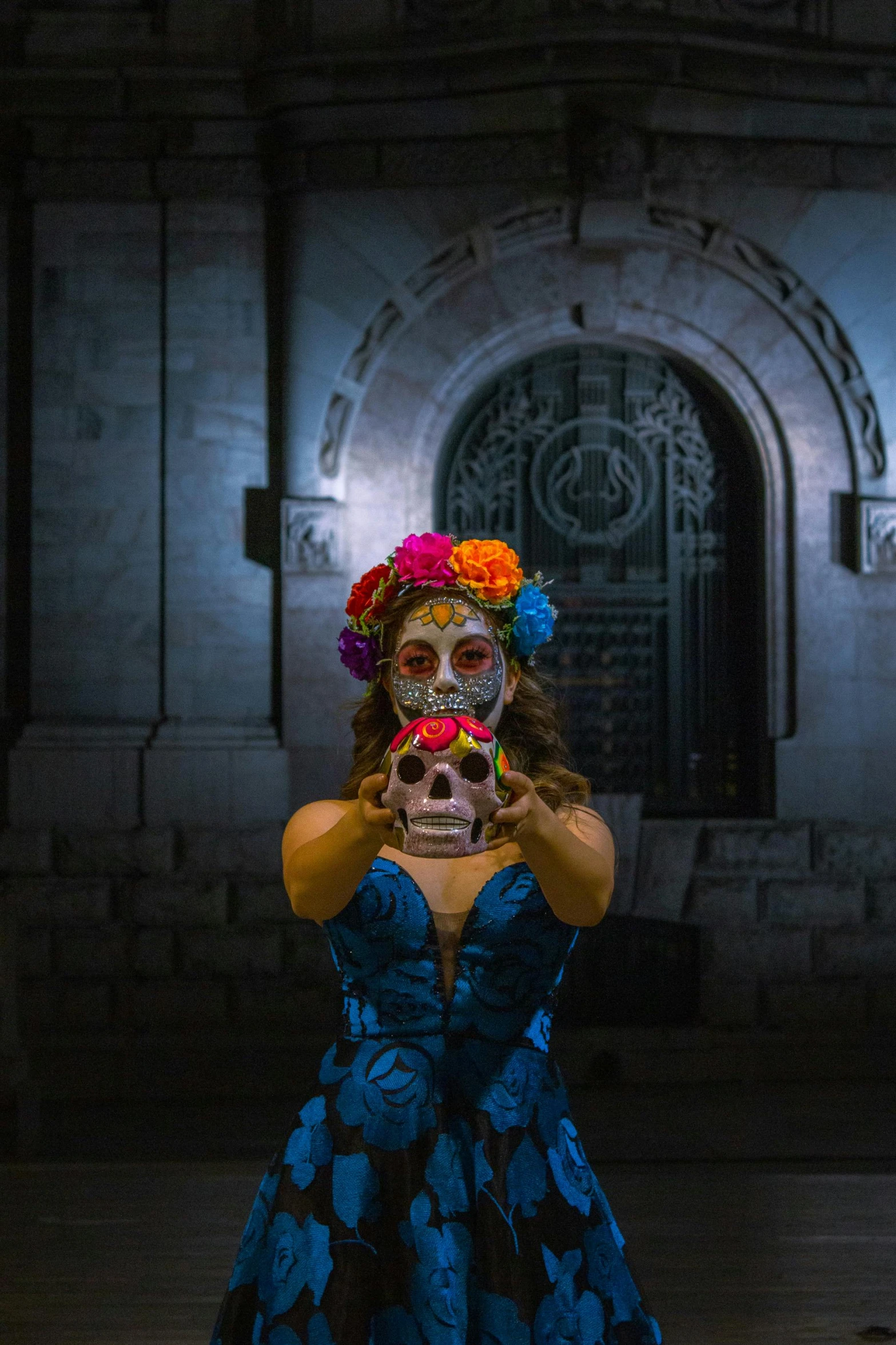 a woman is posing in front of a doorway with a fake skeleton on her face