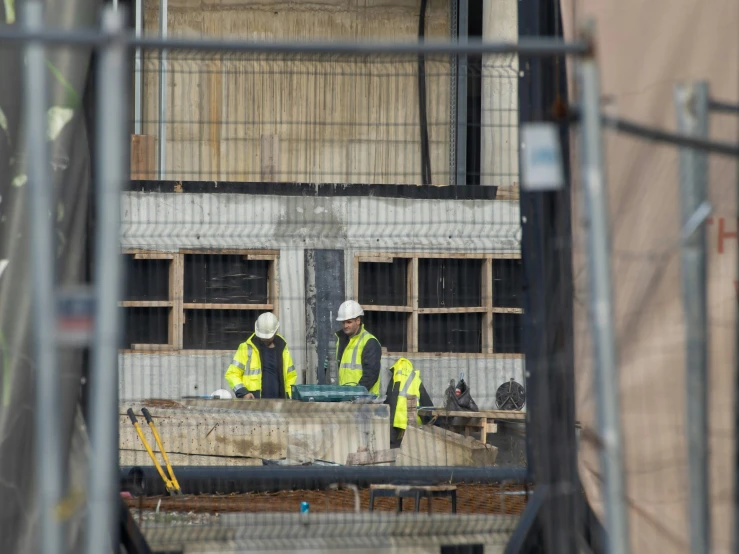 there are two men standing near a construction site