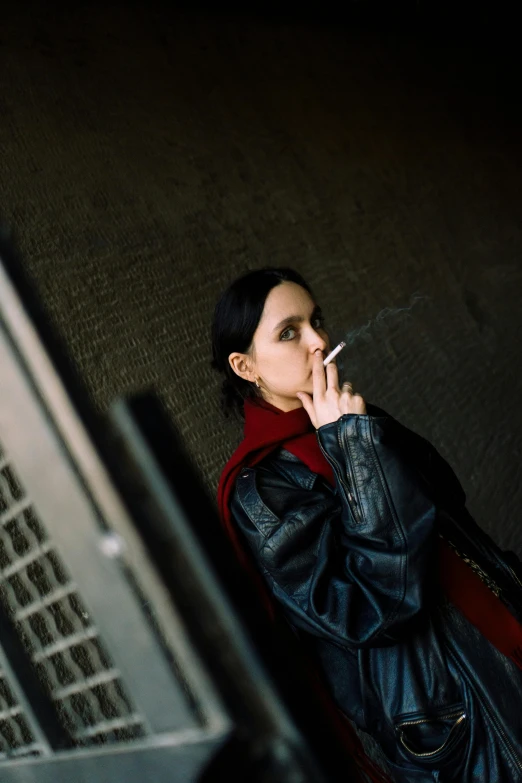 woman smoking cigarette next to her laptop