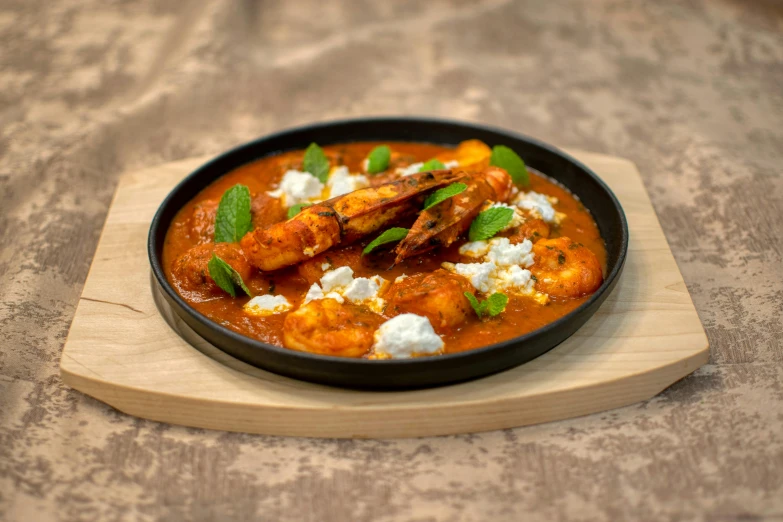 a pan full of stew and other items on a wooden board