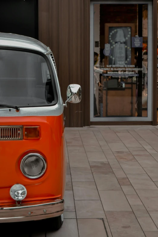 an old red van sits on the sidewalk