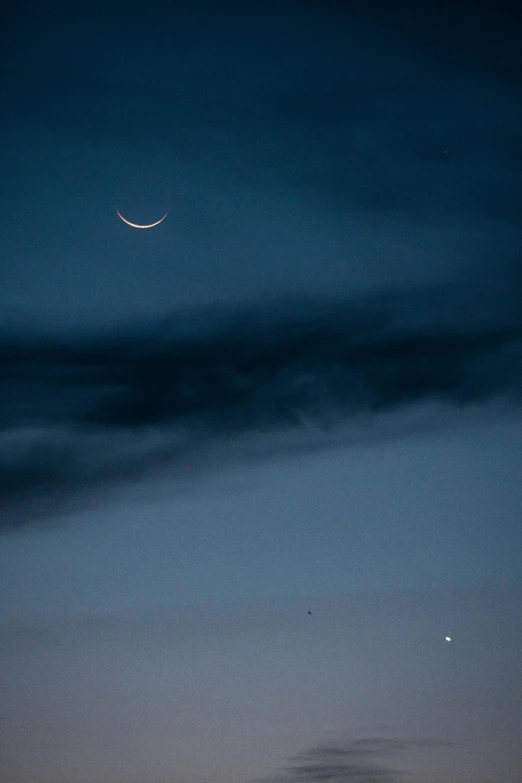 the moon is in the dark over a city skyline