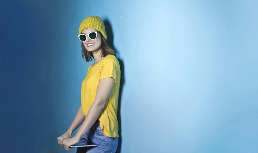 a woman with sunglasses is leaning against the wall