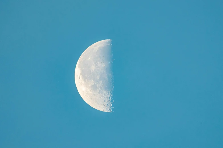 a half moon in the sky with no clouds