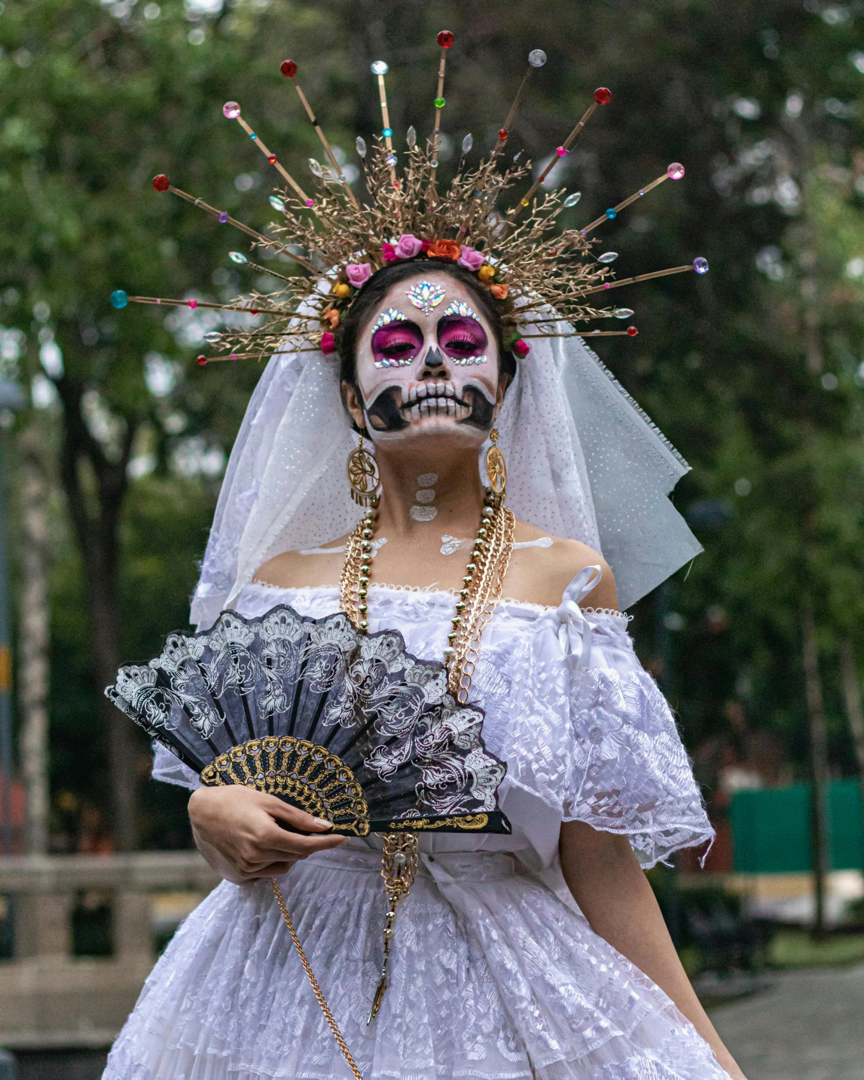 a woman in white dress and mask with a fan on her head