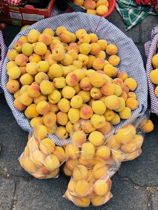 baskets full of peaches are piled on the pavement