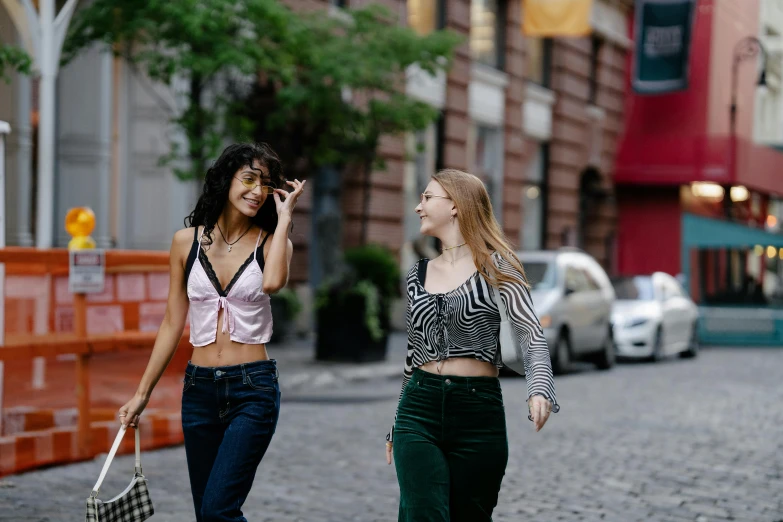 two beautiful women walking down a cobblestone street