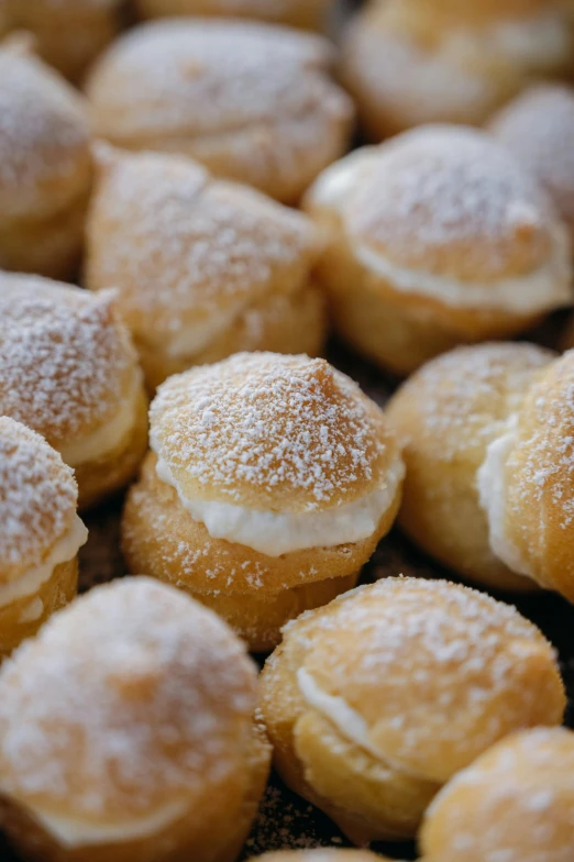 a pile of sugar covered mini donuts on display