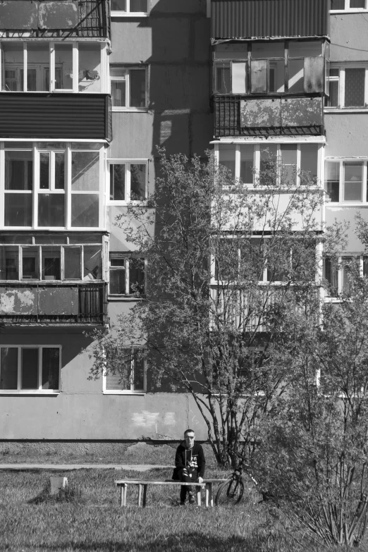 black and white po of a building with people sitting on the bench