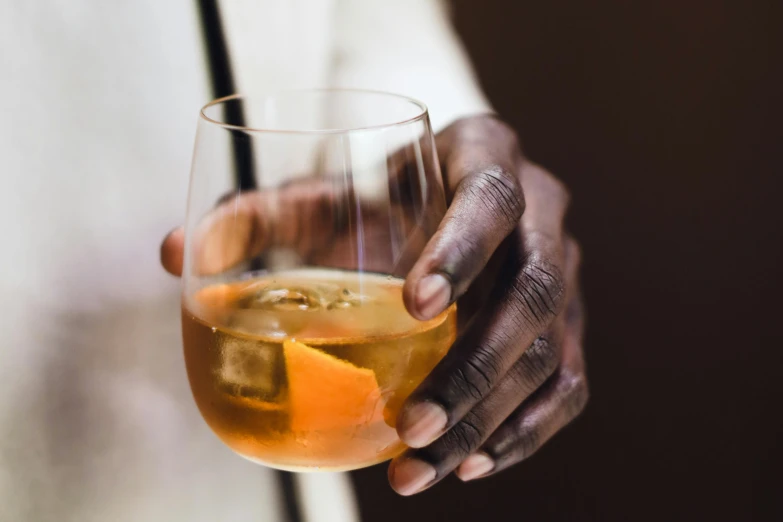 closeup of hands holding up a drink in glass