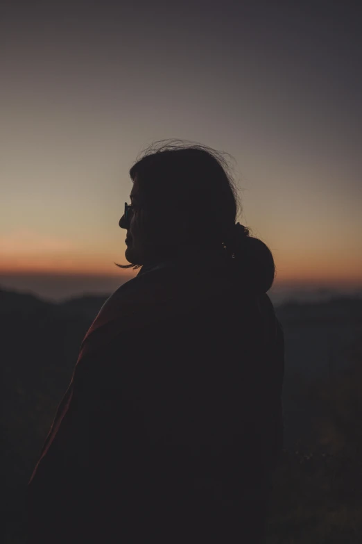 a person is standing on a hill top with the sunset behind them