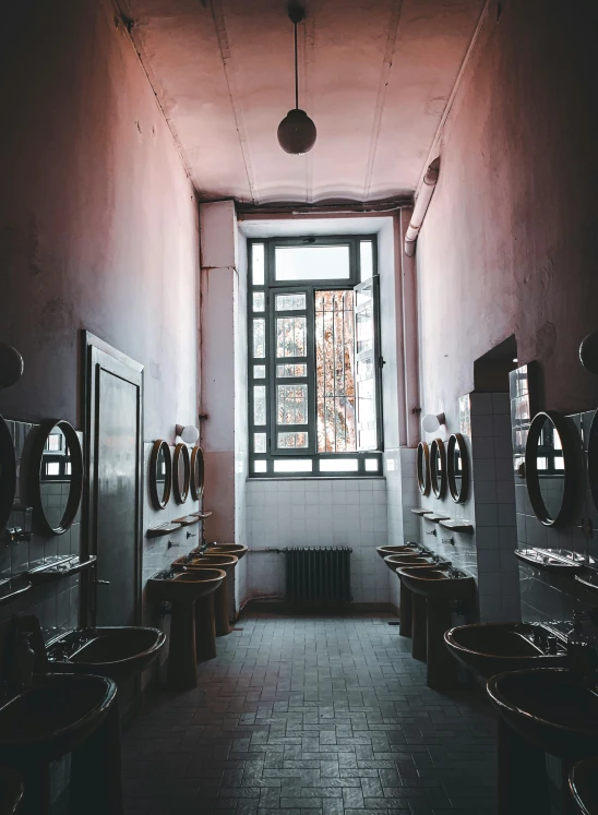 the walls are painted pink and the toilets are lined with mirrors