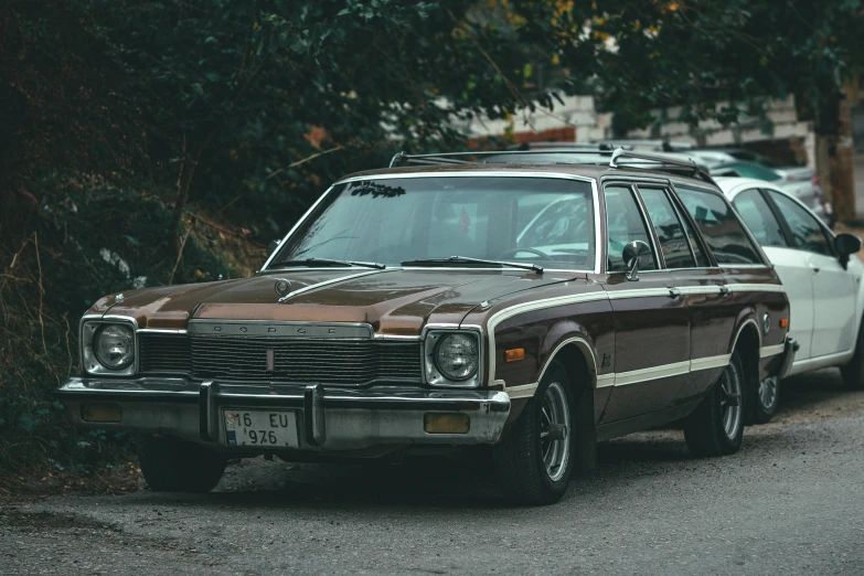 an old fashioned car sits parked on the side of a street