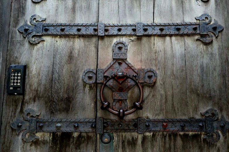 a wooden door with metal latch and iron hardware