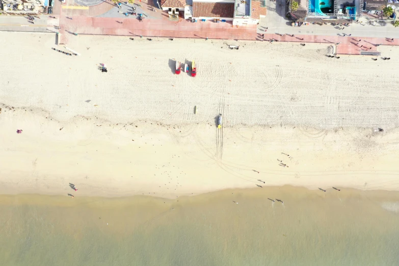 there are people walking and playing on a beach