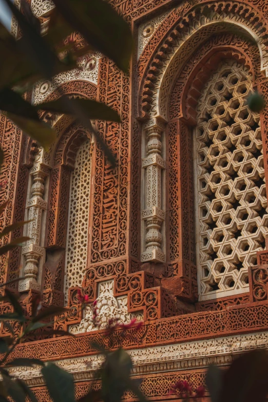 ornate window of red building with carvings in it