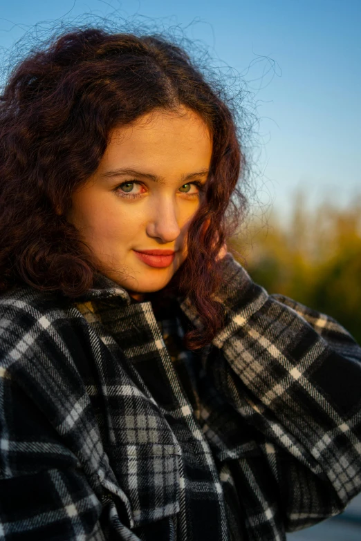 a beautiful young woman with red hair wearing a plaid jacket